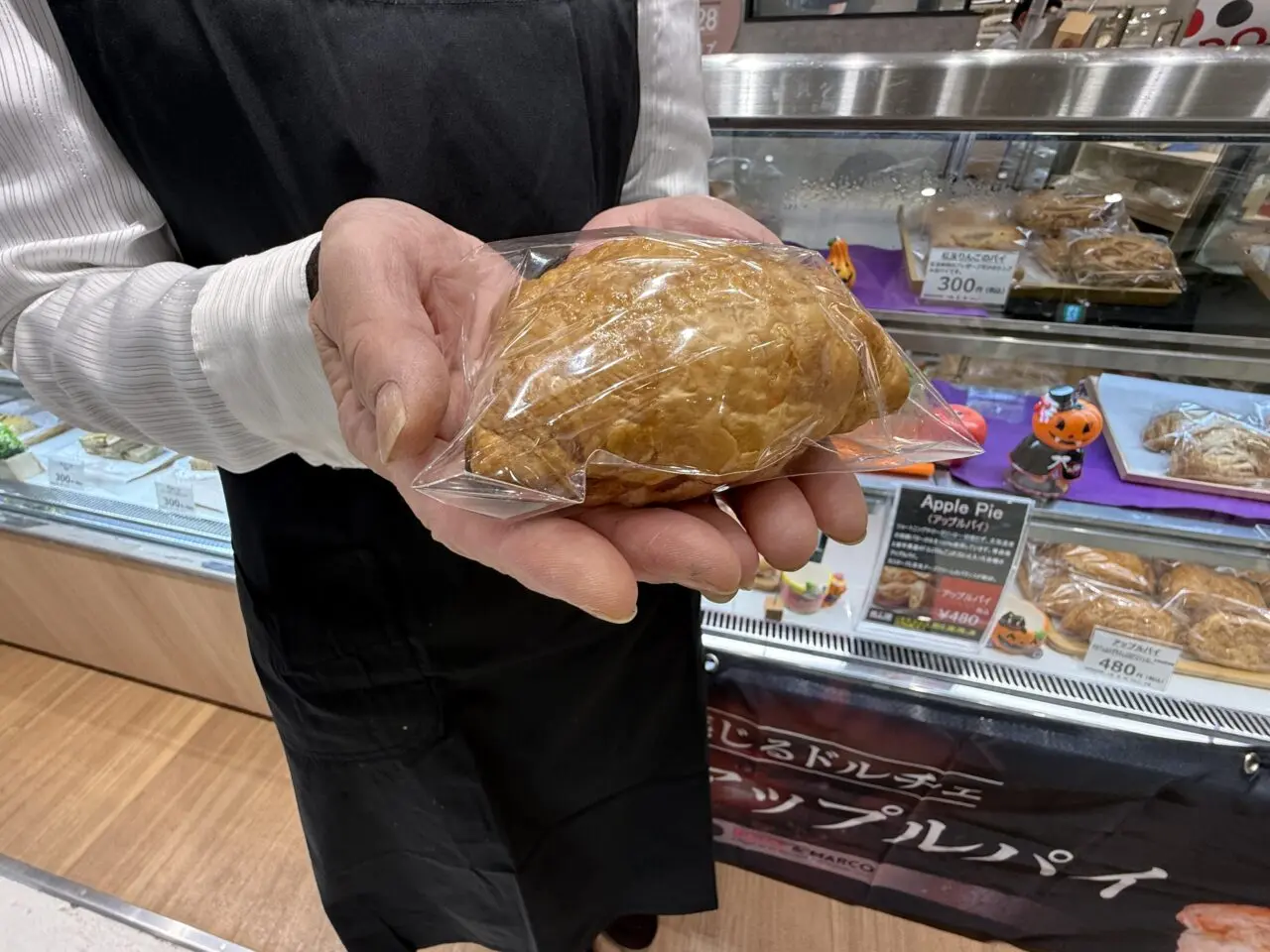 スタッフがアップルパイを手に持つ様子