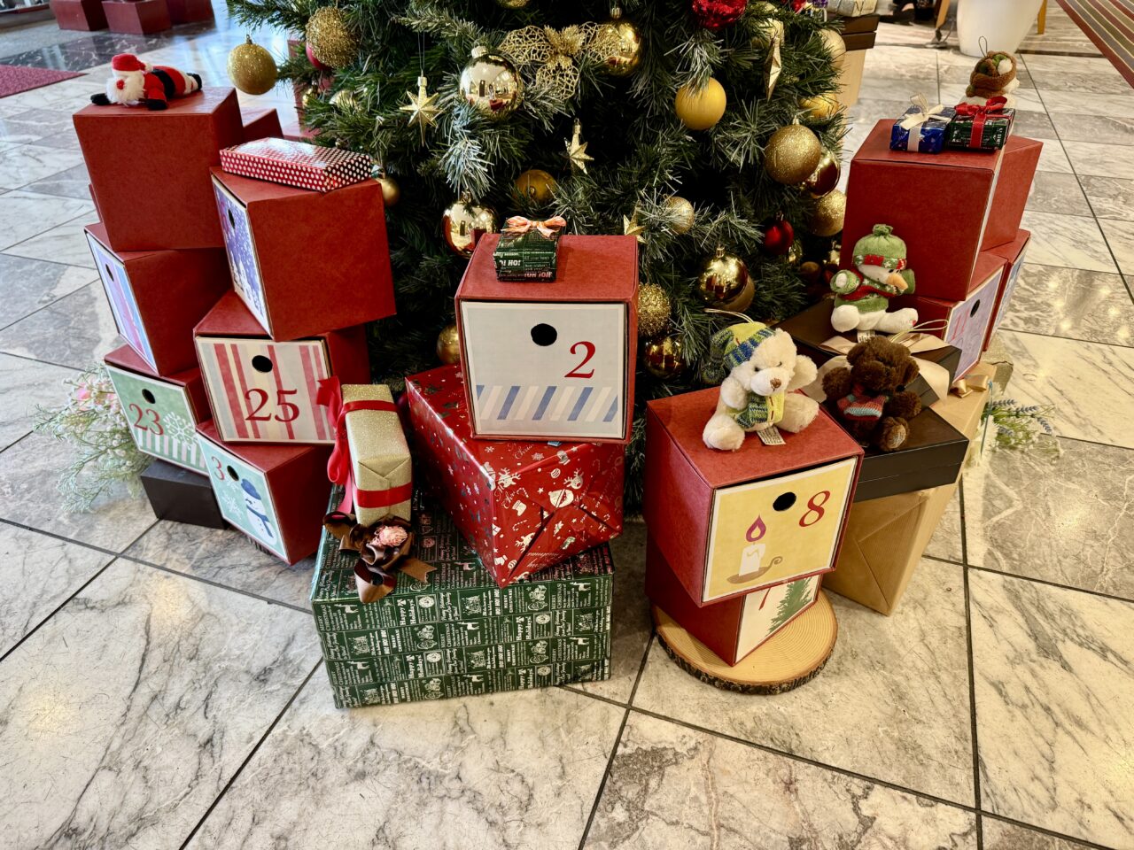 アドベントカレンダーの日付ボックスとぬいぐるみが並ぶ様子