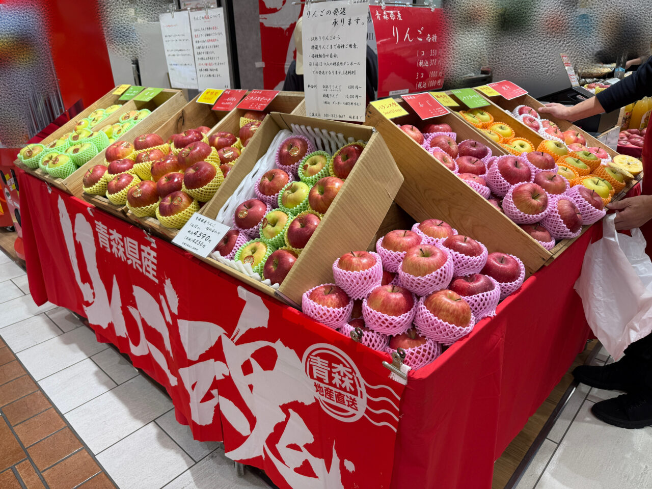 海老名マルイ1階の坂本健商店出店ブース全景。さまざまな品種のりんごが並ぶ。