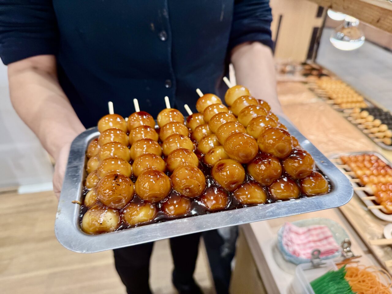 焼きたてのみたらし団子をトレーで提供する様子