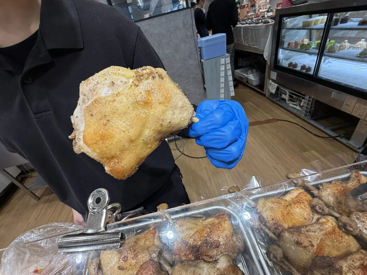 焼きたての骨付鳥を手に持つスタッフ