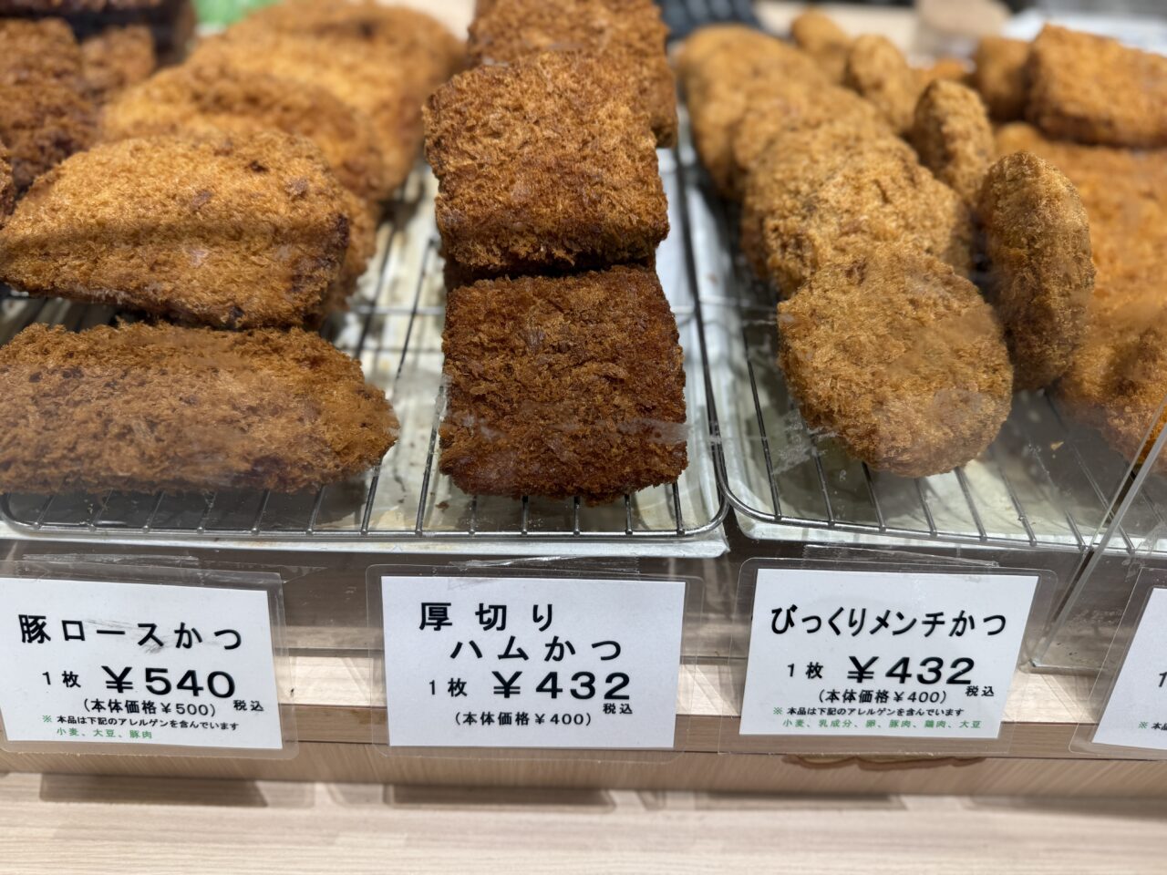 厚切りハムカツやロースカツなど揚げ物惣菜が並ぶショーケース