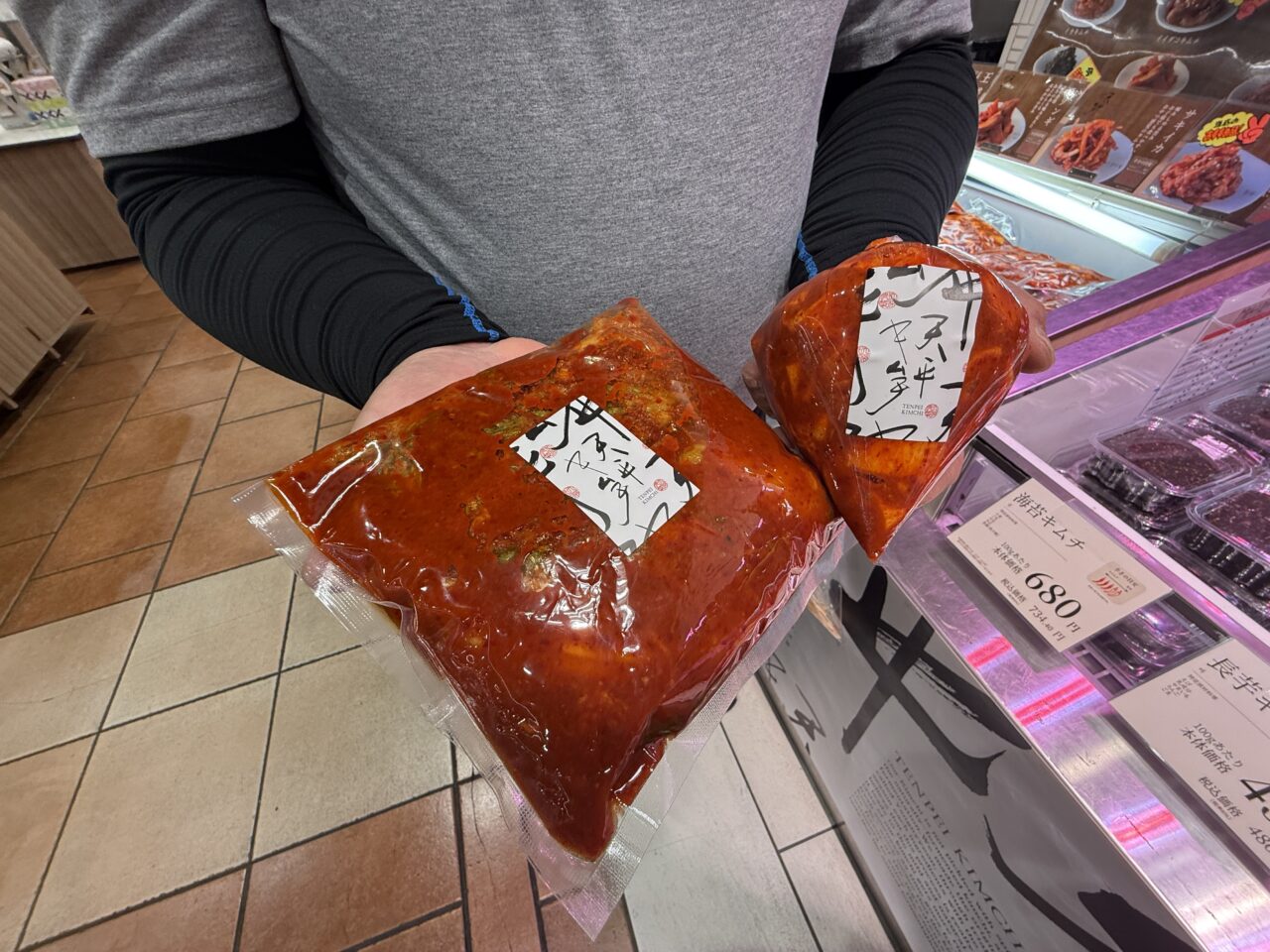 天平フーズスタッフが大容量のキムチパックを手に持っている様子