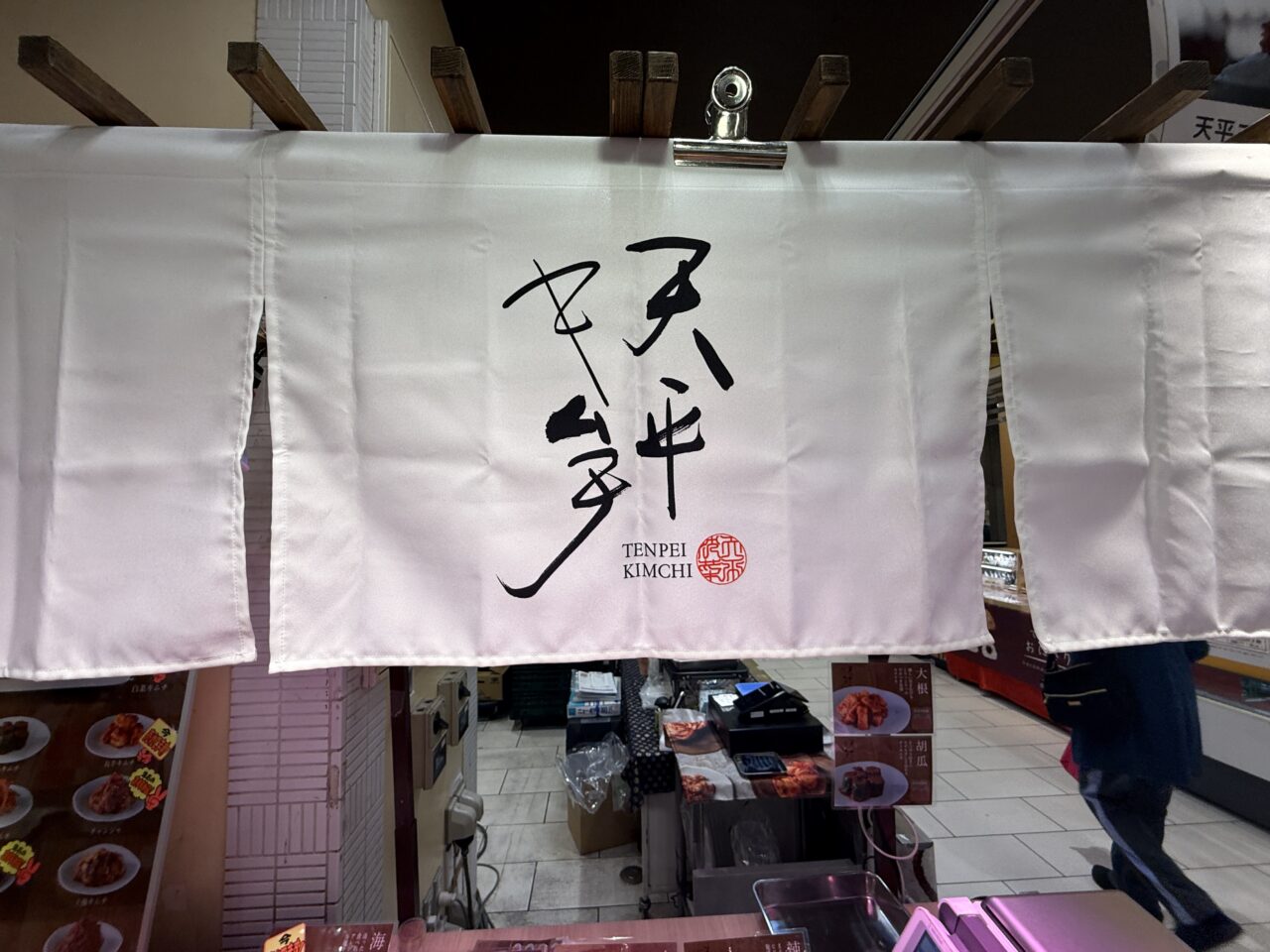天平フーズのキムチ売り場に掲げられた白いのれん
